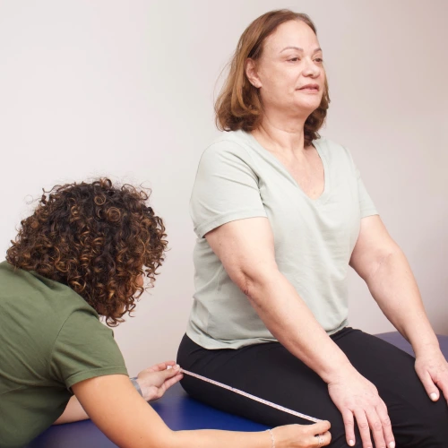 Avaliação de membro inferior com fita métrica em paciente adulta na Gomo Reabilitação Neurofuncional, para prescrição de tecnologia assistiva