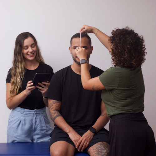 Equipe da Gomo realizando avaliação craniana com fita métrica e registro em tablet